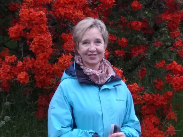 Portrett av kvinne foran blomstrende busk